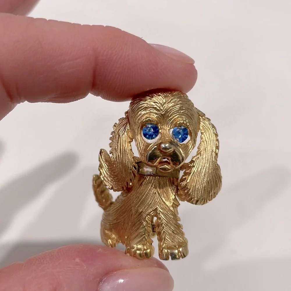 Costume puppy dog pin. Gold tone with blue crystal eyes. New.